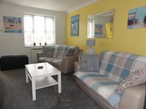 a living room with two couches and a table at Saltburn Holidays Jasmine Cottage Saltburn in Saltburn-by-the-Sea