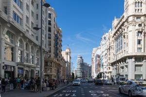 a busy street in a city with buildings at Charming Gran Vía Center in Madrid