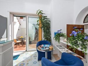 a living room with blue chairs and a table at San Nicola Guest House in Anacapri