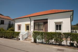 una casa blanca con una valla delante en LAS CASITAS DEL VERDEL, en Suances