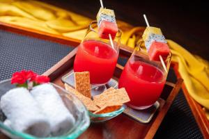 a tray with two glasses of red juice and crackers at RiverTown Hoi An Resort & Spa in Hoi An