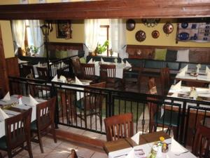 restauracja ze stołami i krzesłami oraz balkonem w obiekcie Pension Schmiedeschänke w Dreźnie