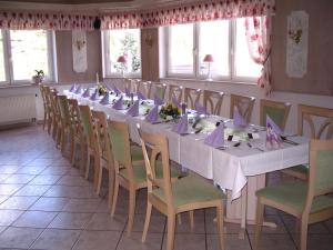 un comedor largo con una mesa larga y sillas en Hotel Schöne Aussicht, en Steinach