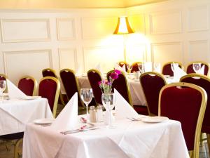 un comedor con mesas y sillas con mantel blanco en The Ryandale Inn, en Dungannon