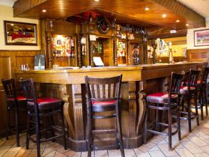 un bar con taburetes de madera en un restaurante en The Ryandale Inn, en Dungannon