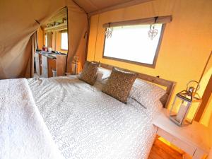 a bedroom with a white bed with a window at Carr's Hill Luxury Safari Tents in Denny