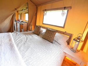 um quarto com uma cama branca e uma janela em Carr's Hill Luxury Safari Tents em Denny