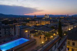 a view of a city at night with a swimming pool at Hotel Kraft in Florence