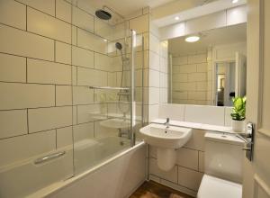 a bathroom with a sink, toilet and tub at Marlyn Lodge – City of London in London