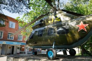 a military helicopter parked in front of a building at Gostinitsa on Martemyanova in Kemerovo