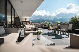 balkon z krzesłami i stołami oraz widokiem na góry w obiekcie Hotel Ciasa Tamá w mieście La Villa