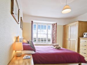 a bedroom with a large red bed with a window at Seaview Inn in Falmouth