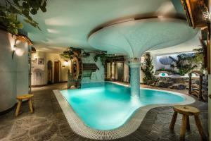 a swimming pool in the middle of a house at Hotel Ciasa Tamá in La Villa