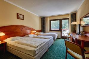 Postel nebo postele na pokoji v ubytování Hotel Lövér Sopron