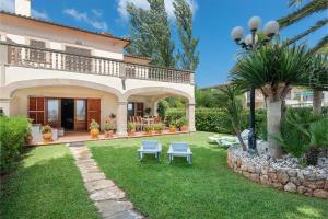 a house with a yard with two chairs and a patio at Chilllife in Port d'Alcudia