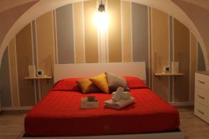 ein Schlafzimmer mit einem roten Bett mit zwei ausgestopften Tieren in der Unterkunft Sesta Strada in Civitavecchia