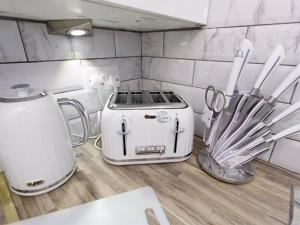 a kitchen counter with a toaster and other kitchen utensils at Shaftesbury Apartment in Leeds