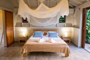 a bedroom with a bed with two towels on it at Shambala Lodge in Le Moule