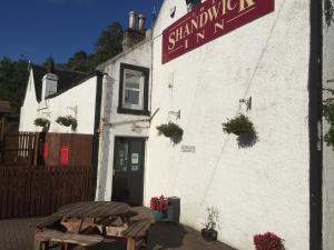 a white building with a table outside of it at The Shandwick Inn in Tain