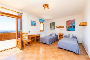 a room with two beds and a desk and a table at Villa Es Puig in S'Horta +23 photos