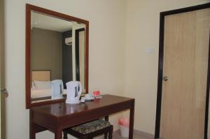 a bathroom with a wooden vanity and a mirror at Senrose Hotel Kuantan in Kuantan