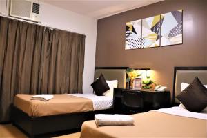Habitación de hotel con 2 camas y ventana en The Studio 18 Residences, en Manila