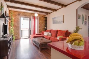 a living room with a red couch and a table at Apartamento Benitez Umpierrez in Cotillo