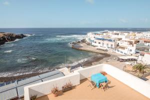 a view of a beach with a blue table and chairs at Apartamento Benitez Umpierrez in El Cotillo