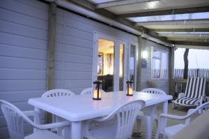 a white table and chairs on the porch of a house at Mobilhome Victory 56 in Quiberon