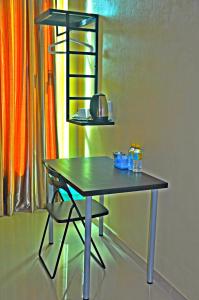 a table with a chair next to a window at Tanjong Inn in Kota Bharu