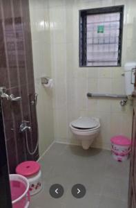 uma casa de banho com um WC e um chuveiro com uma janela em Swapnapurti Bungalow 2BHK em Alibaug