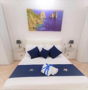 a bedroom with a bed with blue and white pillows at I Tesori di Napoli in Naples