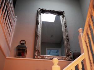 a mirror on a wall next to a staircase at Skyline Guesthouse in Newquay