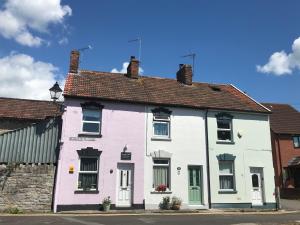 a white and purple house on a street at Glastonbury Rose Cottage in Glastonbury