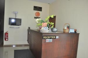 a reception desk with a television on the wall at Tanjong Inn in Kota Bharu