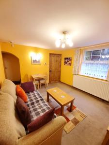 a living room with a couch and a table at Saltburn Holidays Primrose Cottage in Guisborough