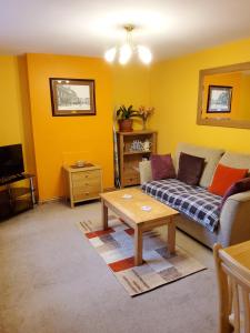 a living room with a couch and a coffee table at Saltburn Holidays Primrose Cottage in Guisborough