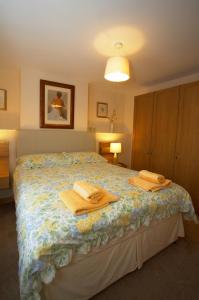 a bedroom with a bed with two towels on it at Saltburn Holidays Primrose Cottage in Guisborough