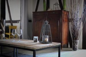 een houten tafel met twee glazen en een lamp erop bij Sous les toits du Zinc - Climatisé in Colmar