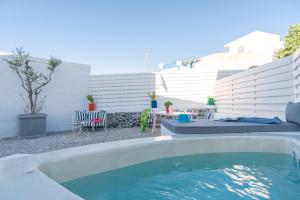 a swimming pool in a backyard with a table and chairs at LAGADI SUITES by K&K in Mesaria