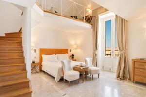 a bedroom with a bed and a table and chairs at Palazzo del Corso – Boutique Hotel in Gallipoli +37 photos