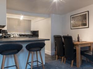 a kitchen with a table and some black chairs at Southernhay Basement Apartment in Exeter