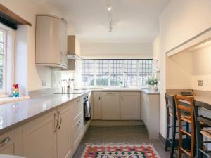een keuken met witte kasten en een groot raam bij Oak House Farm in Edenbridge