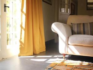 a living room with a white couch and a yellow curtain at Oak House Farm in Edenbridge