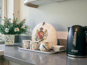 a counter with cups and a toaster on a counter top at Oak House Farm in Edenbridge