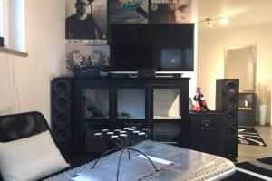uma sala de estar com um centro de entretenimento com uma televisão e altifalantes em nice Apartment em Schwarzenbruck