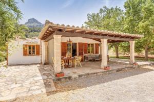 a stone patio with a wooden pergola at Finca L'hort Nou in Pollença