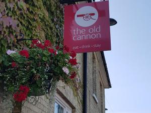 um sinal na lateral de um edifício com flores em The Old Cannon Brewery em Bury Saint Edmunds