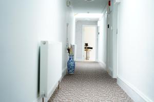 a hallway with a blue vase in the middle of a room at Serviced Property Plymouth in Plymouth
