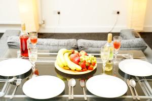 a table with a bowl of fruit and wine glasses at Serviced Property Plymouth in Plymouth